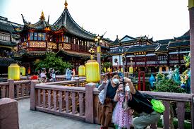 Travelers using their phones in a bustling Chinese city, highlighting connectivity needs.